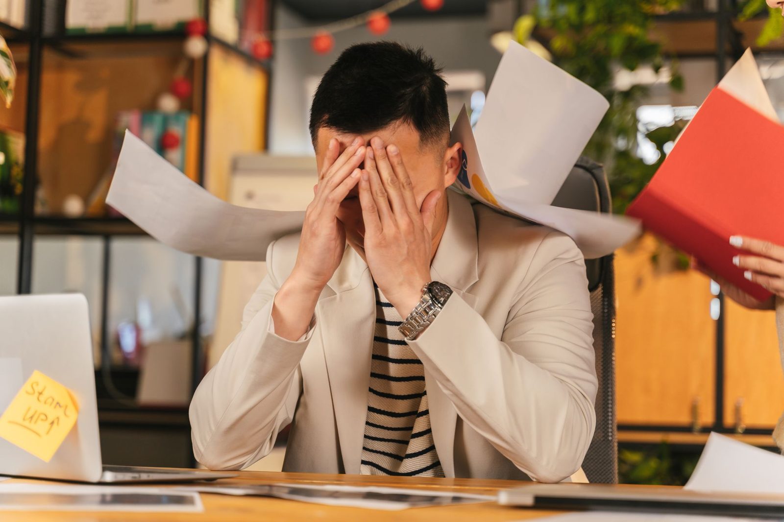 Man at his desk with his head in his hands